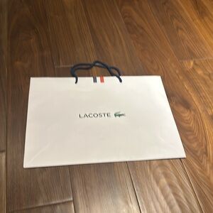 Two Lacoste paper bags.
